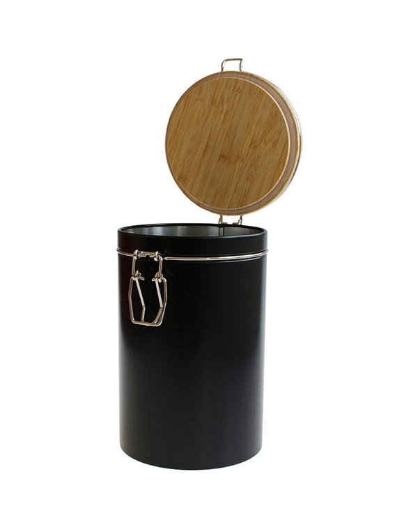Boîte de rangement ronde ouverte en métal noir avec couvercle en bambou brun clair relevé et fermeture à charnière couleur argent, debout sur fond blanc.