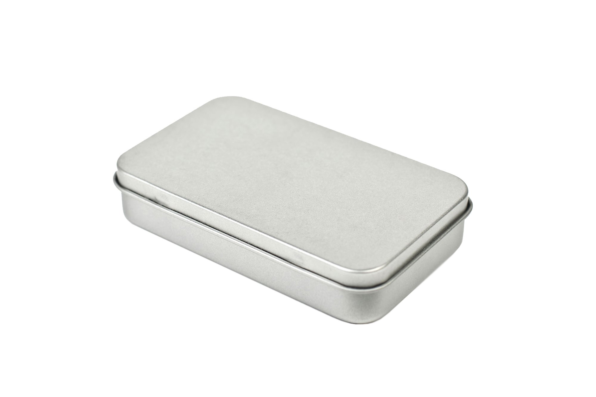 Boîte de poche plate et rectangulaire en métal couleur argent avec couvercle à pince surmoulé, fermée, photographiée sur fond blanc.