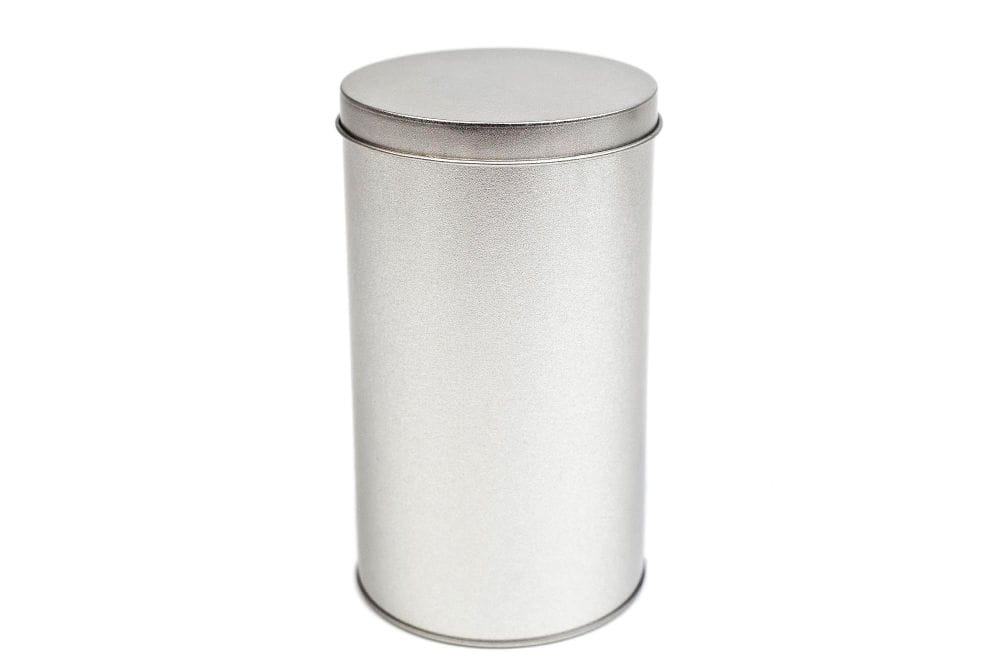 Boîte en fer blanc ronde fermée en métal argenté avec couvercle emboîtant rapporté, fond neutre.