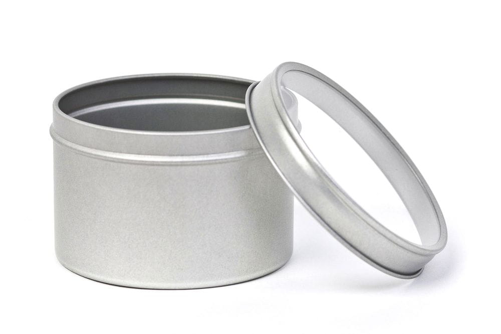 Boîte à herbes métallique ronde ouverte couleur argent avec couvercle retiré doté d'une fenêtre transparente, sur fond blanc.