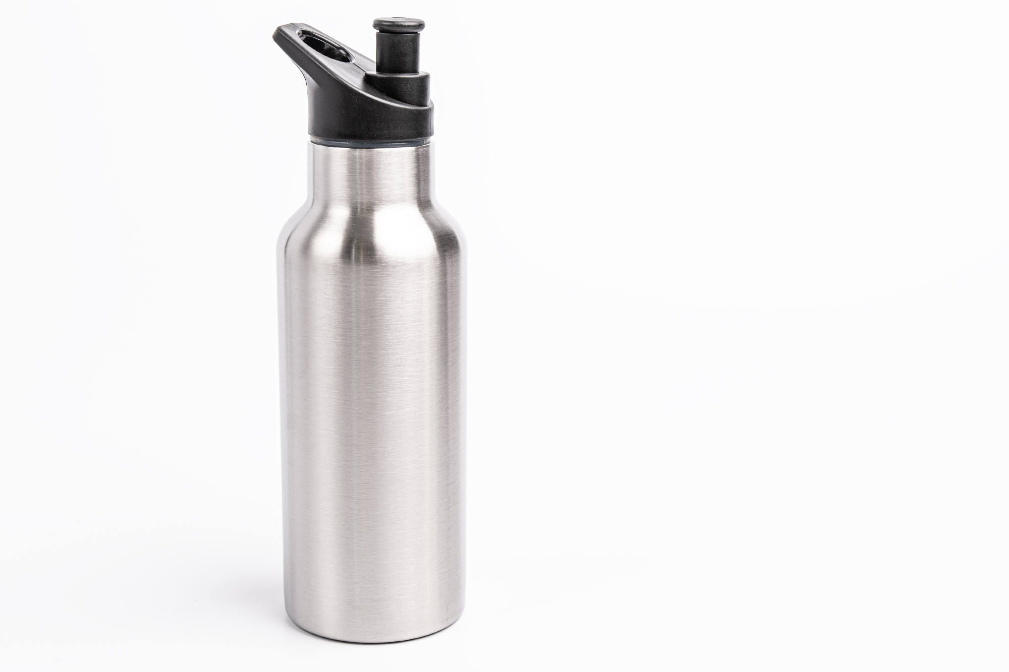 Bouteille isotherme en acier inoxydable fermée avec couvercle noir pop-up en plastique, photographiée sur fond blanc.