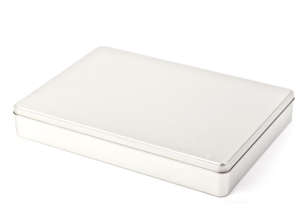 Boîte DIN-A4 fermée, plate, en fer blanc de couleur argentée avec couvercle amovible, photographiée sur fond blanc neutre.