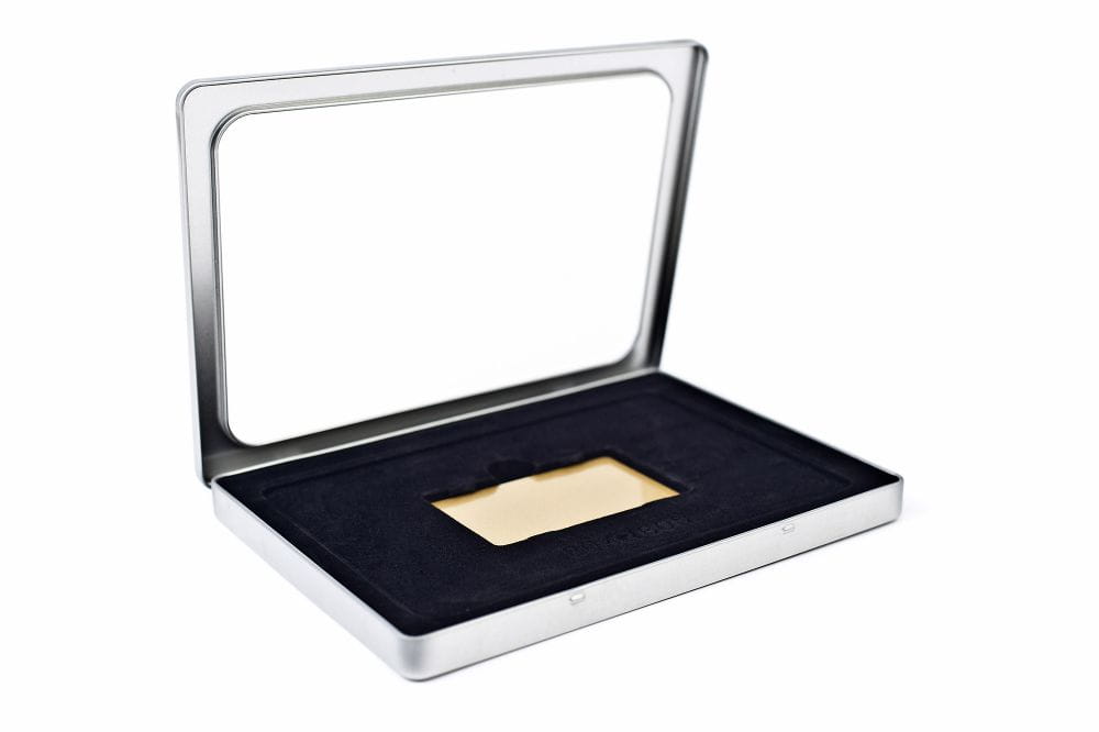 Boîte métallique rectangulaire ouverte en métal couleur argent avec fenêtre de visualisation transparente dans le couvercle et doublure noire, photographiée sur fond blanc.