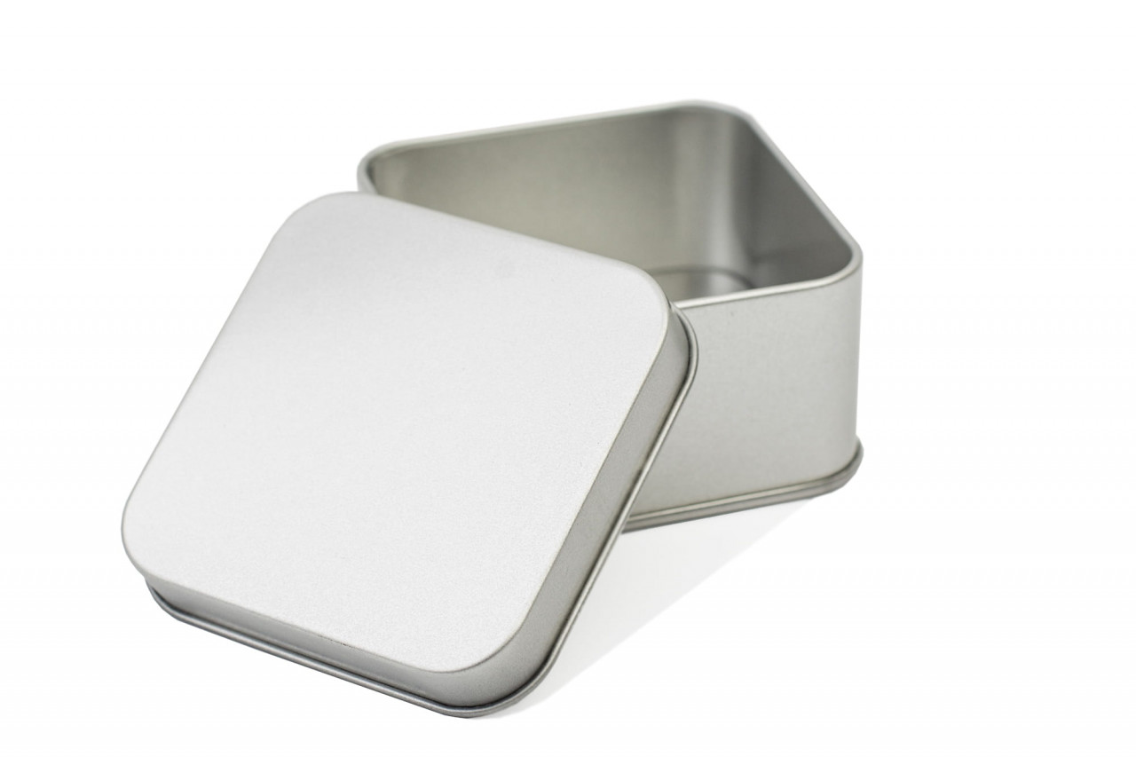 Boîte à chocolats carrée ouverte avec couvercle emboîtant retiré, couleur argent, présentée sur fond neutre.