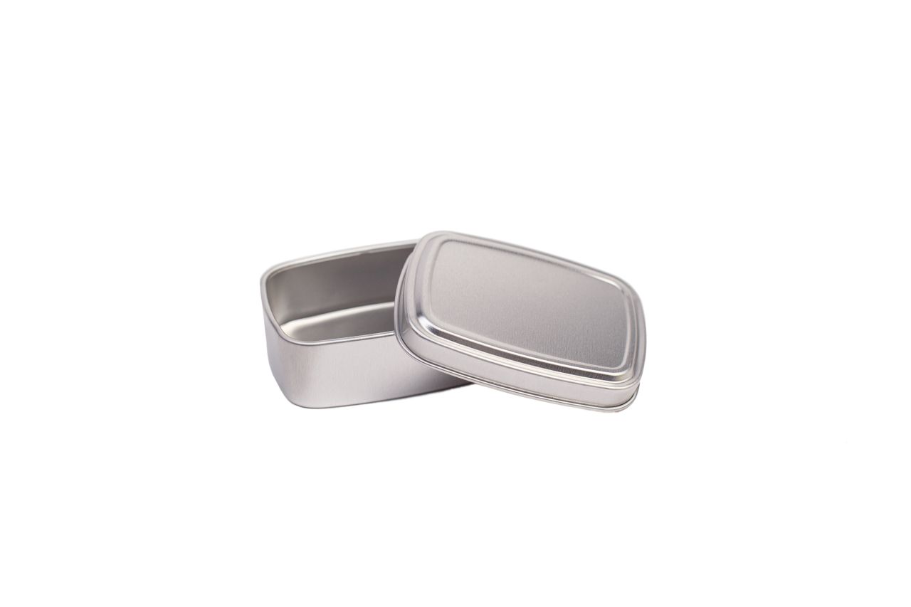 Boîte rectangulaire ouverte en aluminium couleur argent avec couvercle emboîtant légèrement posé, photographiée sur fond blanc.