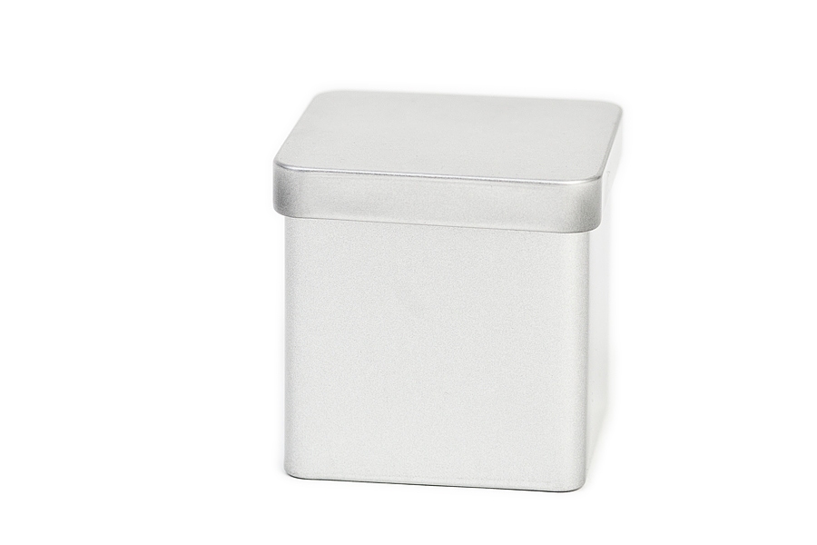 Boîte en fer blanc carrée fermée avec couvercle emboîtant, posée sur fond blanc