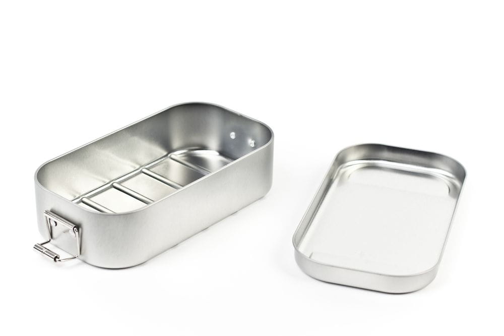 Boîte à lunch rectangulaire ouverte en acier inoxydable de couleur argent avec couvercle retiré et fermetures à clips latérales, intérieur avec séparateur amovible, photographiée sur fond blanc.