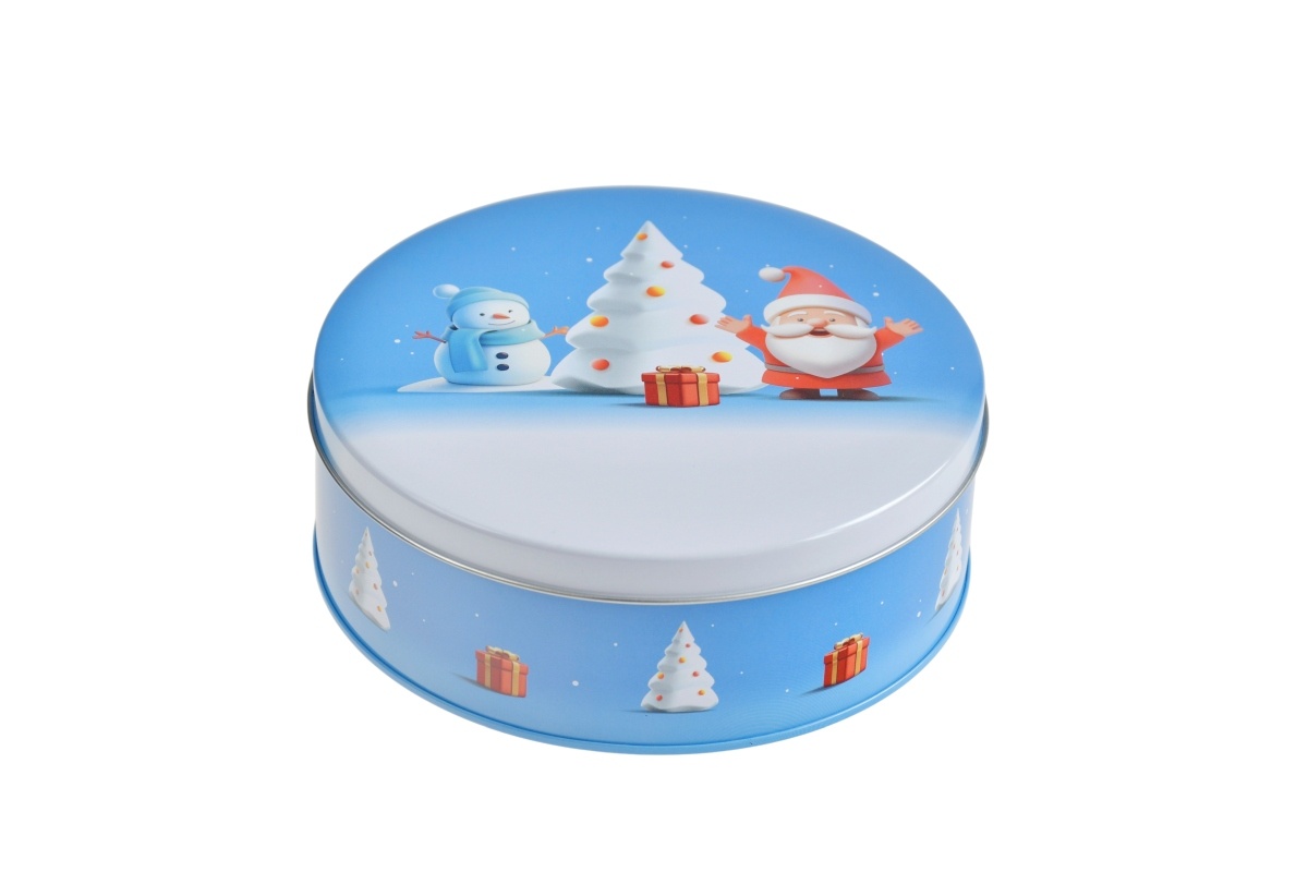 Boîte métallique ronde fermée avec motif hivernal sur fond bleu, représentant un Père Noël, un bonhomme de neige, un sapin et un cadeau, photographiée sur fond blanc.