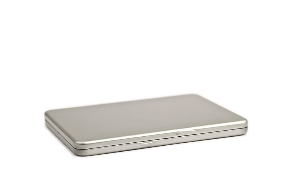 Boîte métallique DVD rectangulaire fermée en métal couleur argent, design épuré, fond neutre.