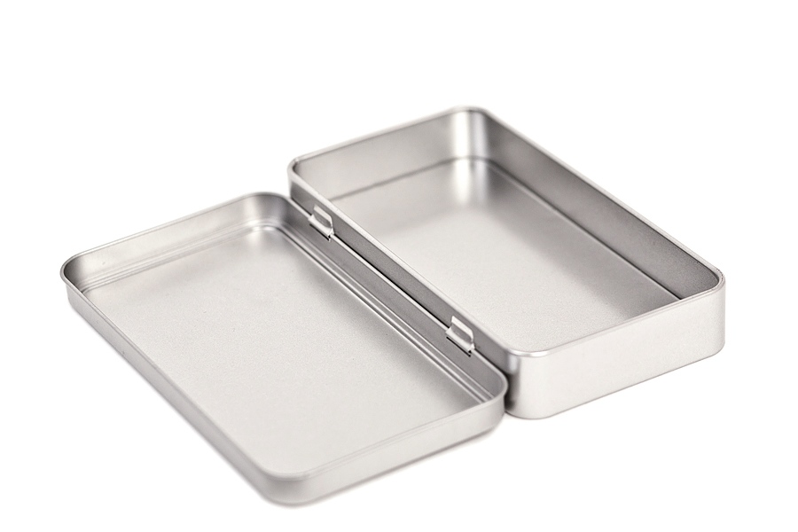Emballage métallique rectangulaire ouvert en tôle couleur argent avec couvercle à charnière entièrement déplié, photographié sur fond blanc.