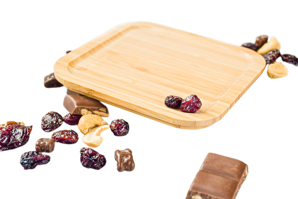 Vue latérale du couvercle en bambou carrée à côté de fruits secs – pièce de rechange respectueuse de l'environnement pour lunch box.