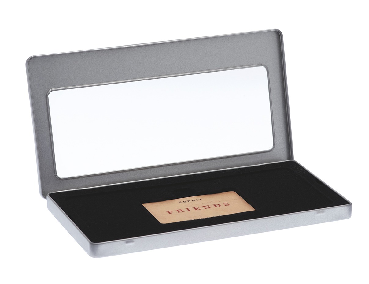 Boîte à bon d'achat rectangulaire ouverte en métal couleur argent avec fenêtre de visualisation dans le couvercle, doublure noire avec carte de bon d'achat à l'intérieur, photographiée sur fond blanc.